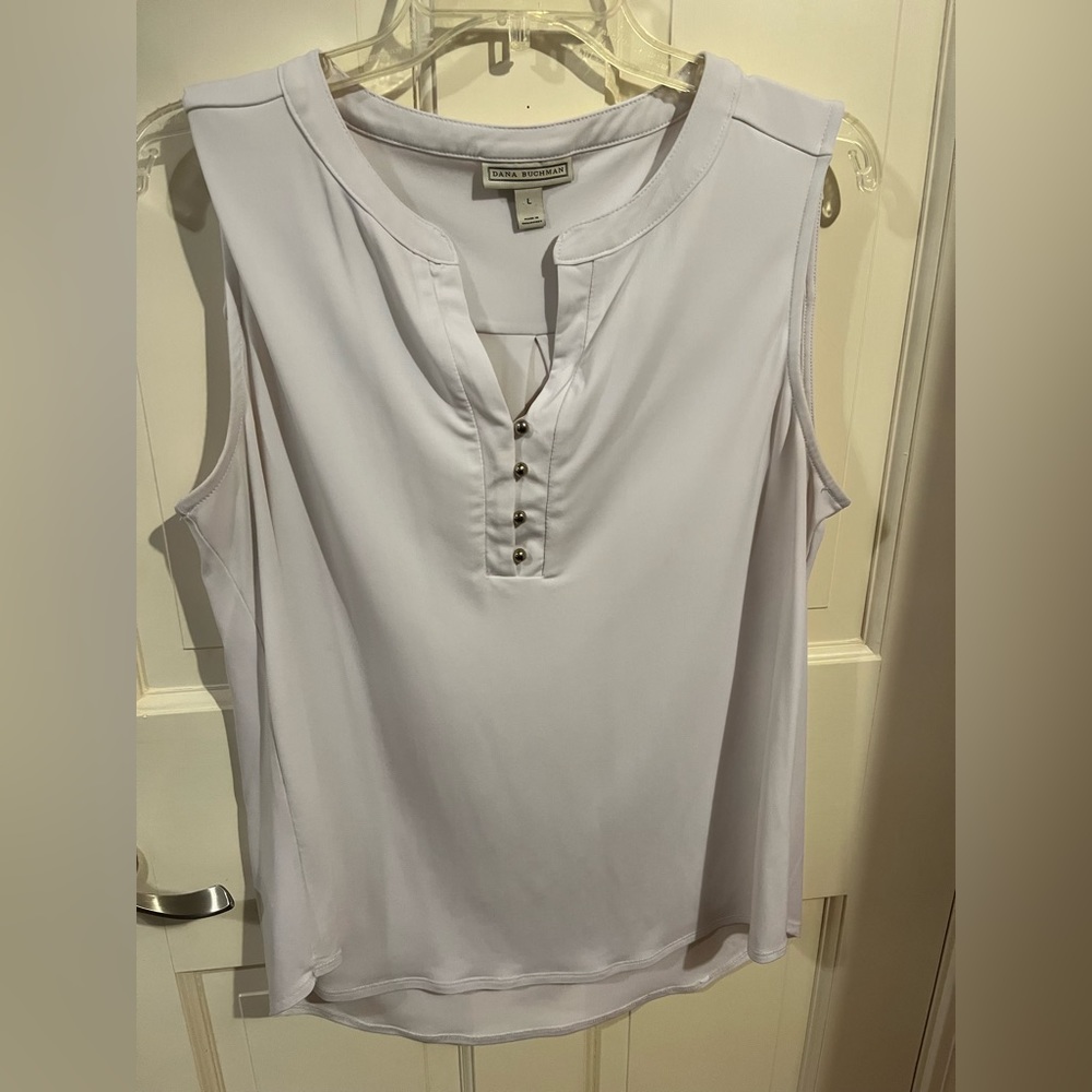 Sleeveless white top with 4 silver buttons.